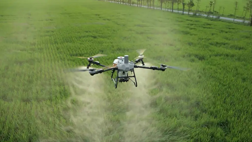 DJI Agras T55 em voo, pulverizando uma lavoura